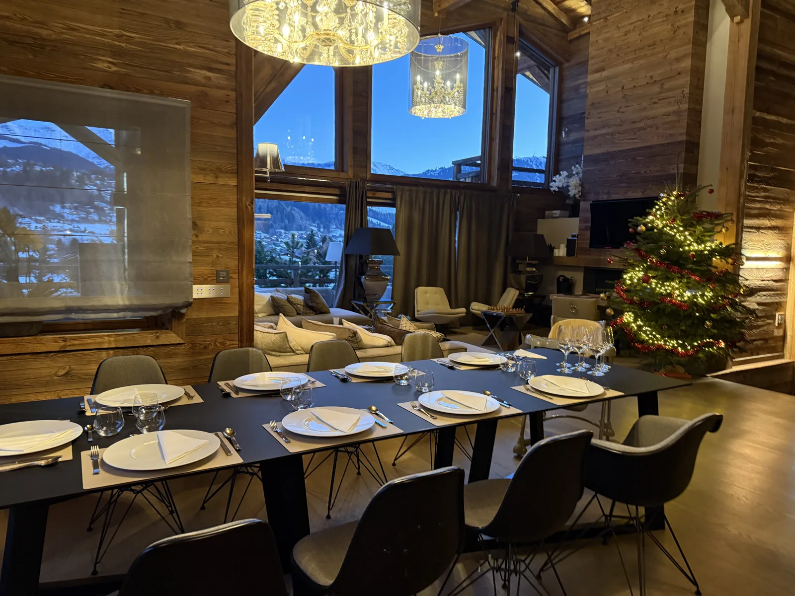 Table de Réveillon dressée dans un chalet face à la montagne enneigée