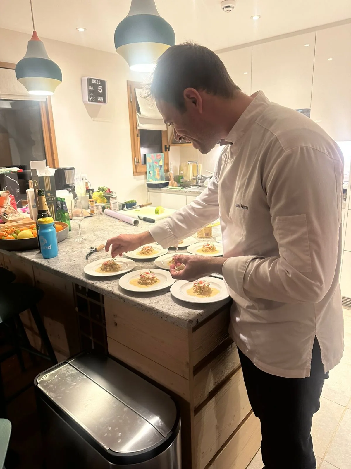 Chef Adam Brunet préparant un plat gastronomique à domicile