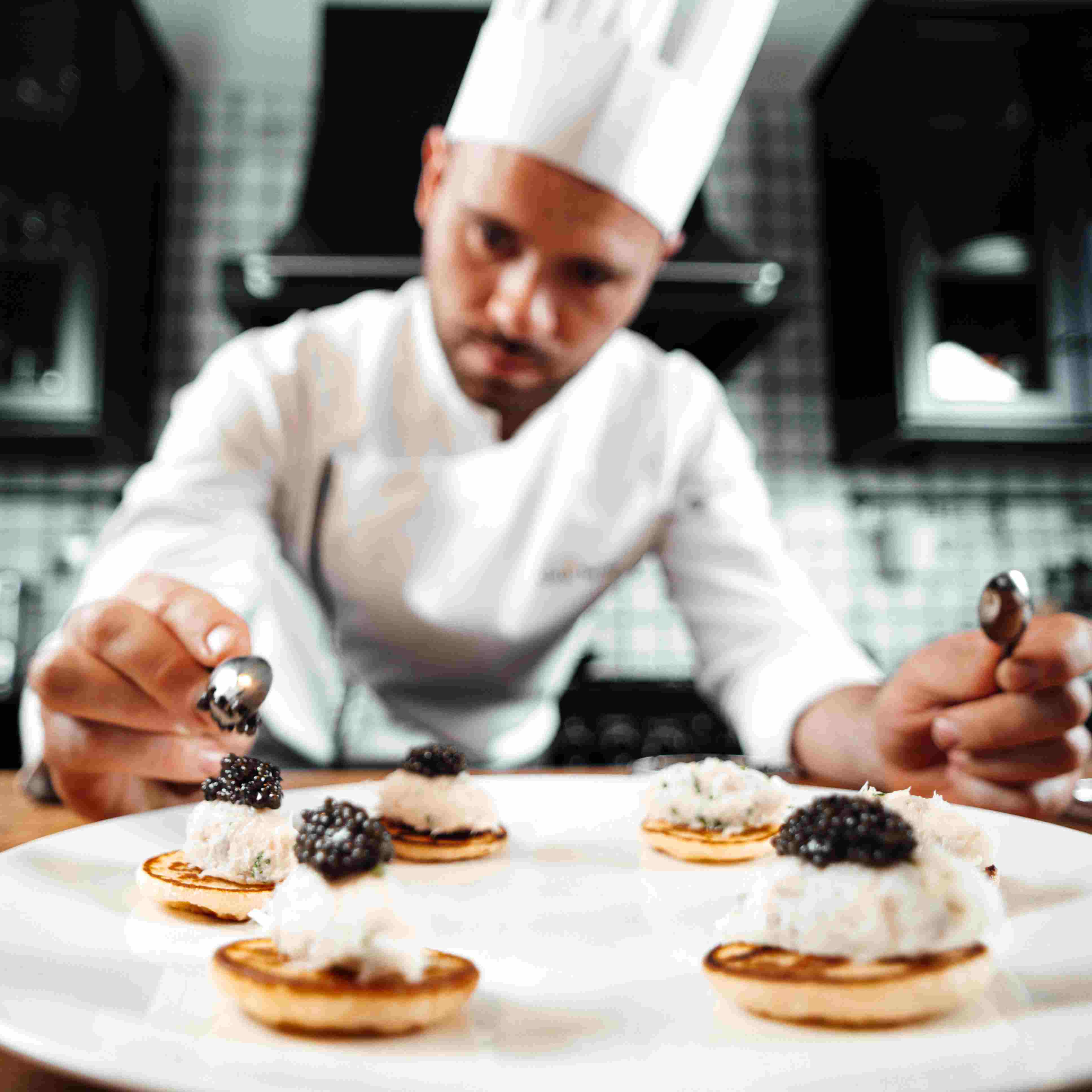 Chef Adam Brunet préparant un plat gastronomique