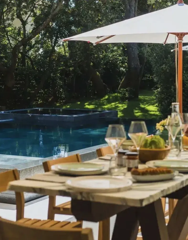 Dinner table set by the pool of a villa
