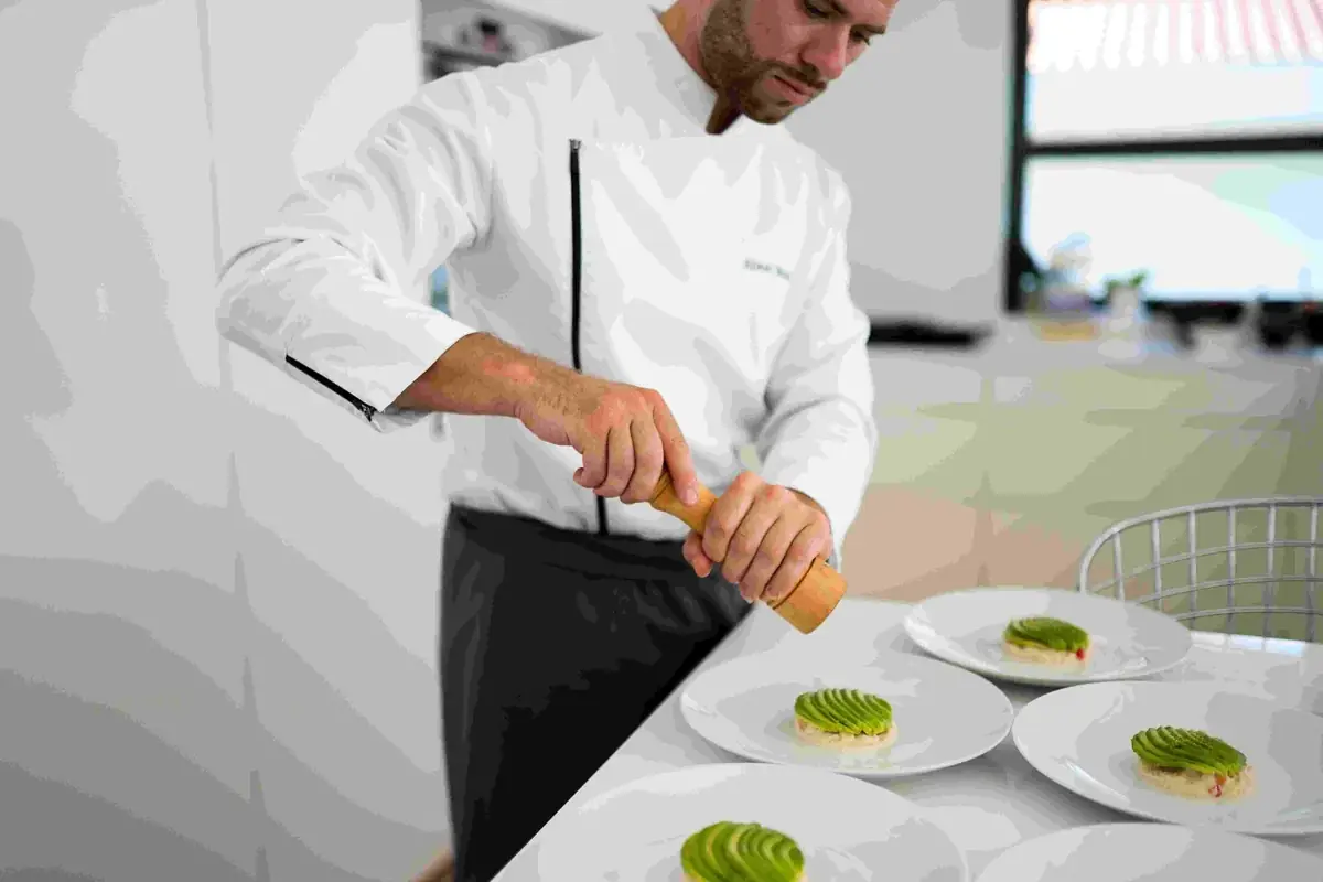 The chef plates the dishes in front of guests in a villa