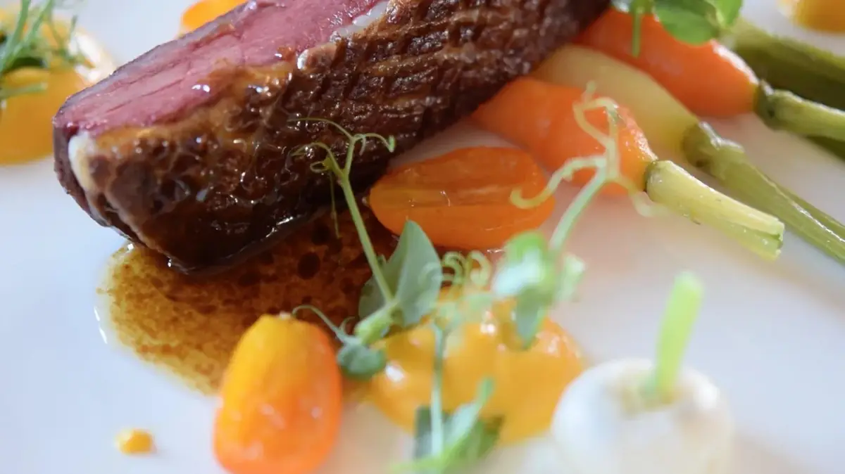 Rosy duck breast with spring vegetables served in a villa