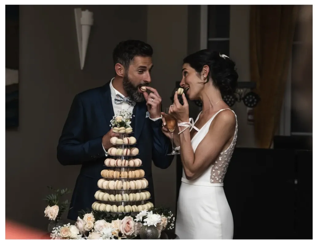 Les mariés devant leur pièce montée de macarons